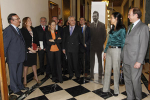 El presidente del Senado, Pío García-Escudero, y la presidenta del Parlamento gallego, Pilar Rojo (derecha de la foto), junto a una imagen de la exposición en la que aparece Mariano Rajoy.