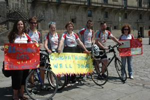 El comité de bienvenida, con las pancartas, posa en el Obradoiro con los ciclistas.