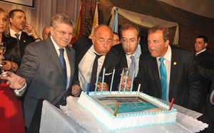 El cónsul, Camba, el consejero de Empleo y el presidente del Centro Gallego soplando la tarta.