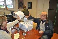 Un emigrante gallego deposita el sobre de votación en la urna en el Consulado español en Montevideo.