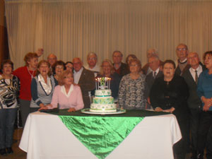 Los miembros de la entidad junto a la tarta aniversario.
