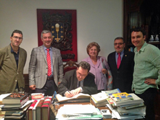 Autoridades que asistieron a la inauguración de la muestra firmando en el libro de honor del Centro Galego.