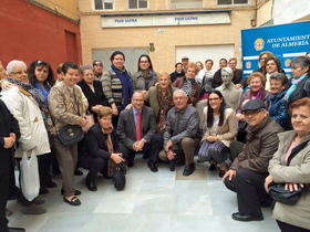 Miembros de Asaler con el alcalde de Almería rodeando la estatua de homenaje al emigrante.