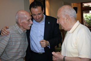 El consejero de Presidencia, Guillermo Martínez, con dos emigrantes asturianos en el Club Tinetense de Buenos Aires.