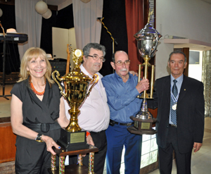 El presidente y la secretaria del Centro Asturiano Casa de Asturias reciben los trofeos.