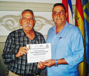 Manuel Barros (izquierda) recibió el Diploma de Reconocimiento de manos del presidente de la entidad, Armando L. Estévez.
