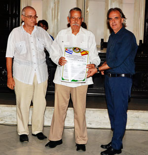 El delegado de España Exterior en Cuba, Manuel Barros, recibió el Reconocimiento Cervantes de manos del cónsul Carlos Ruiz (drcha) en presencia del presidente de la FSEC, Julio R. Santamarina.
