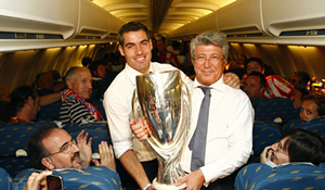 Antonio López, capitán del Atlético, y Enrique Cerezo, presidente, con la Supercopa en el avión de regreso.