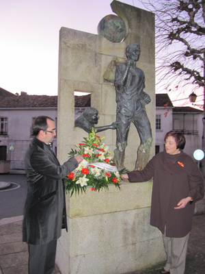 El alcalde Jorge Tuñas y una emigrante retornada en la ofrenda floral ante el Monumento al Emigrante.