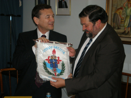 El presidente del Centro Galicia, José María Vila Alén, le entrega a Caamaño el banderín de la institución.