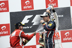 Alonso riega con champán a Vettel en el podio del Gran Premio de la India.