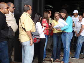 La precandidata María Corina Machado a las puertas     de la Fiscalía General de Venezuela rodeada por periodistas y afectados, revisa los expedientes ante de su denuncia.