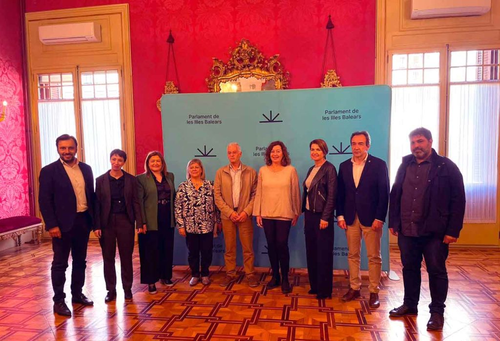 En el centro la presidenta del Govern Balear, Francina Armengol, con dos miembros de la Agrupación Balear de San Pedro, Argentina, y los representantes de los partidos políticos que asistieron a la votación de la nueva ley.