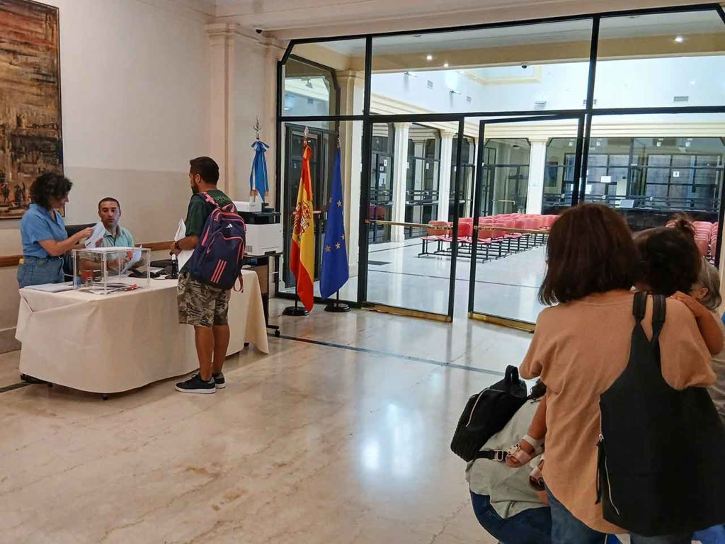 Carlos Daniel Perri Pérez ejerce su derecho a voto en Buenos Aires mientras lo espera su familia.