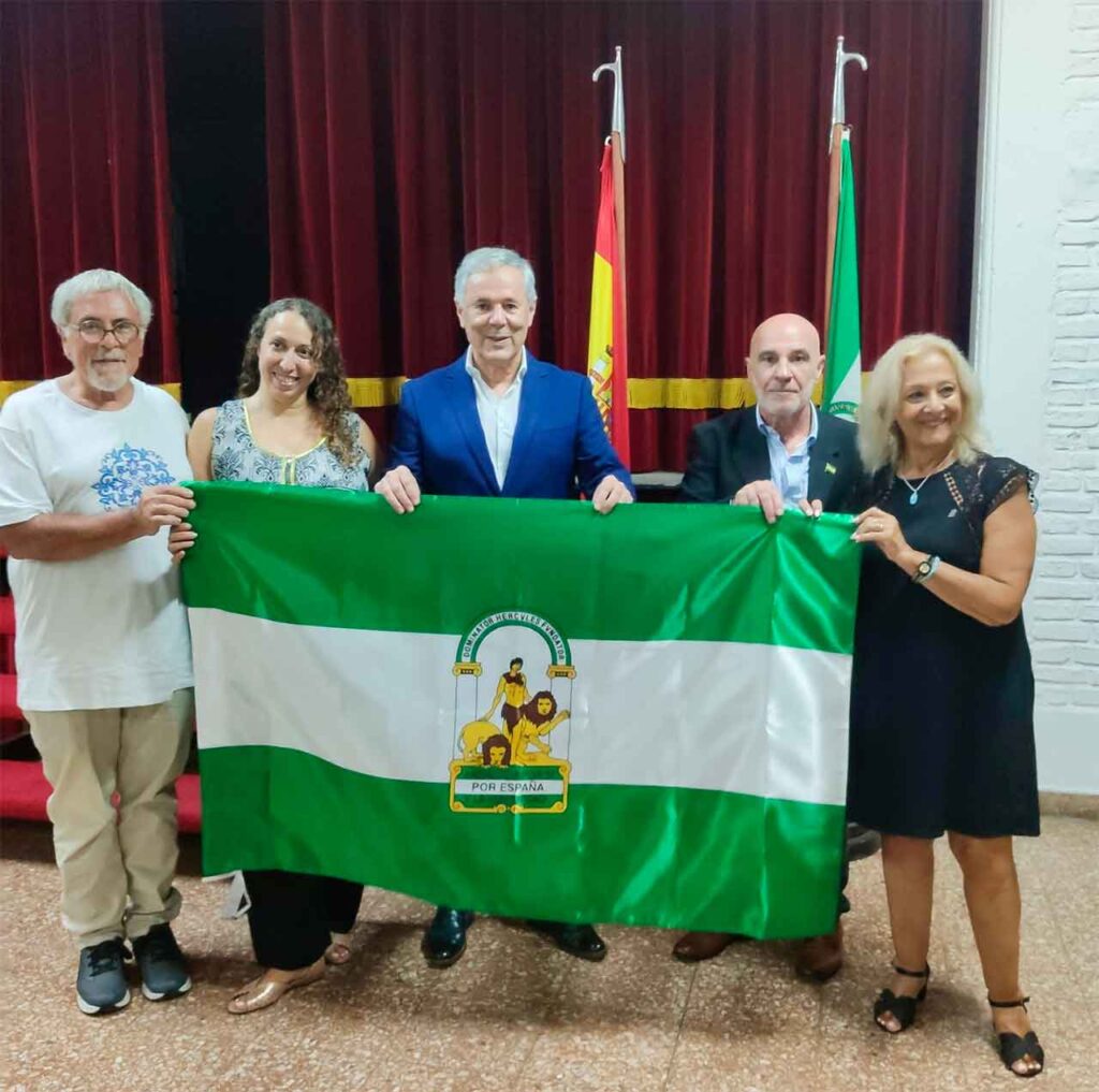 En el centro, Carlos Santos y Miguel Berenguer con la bandera de Andalucía.
