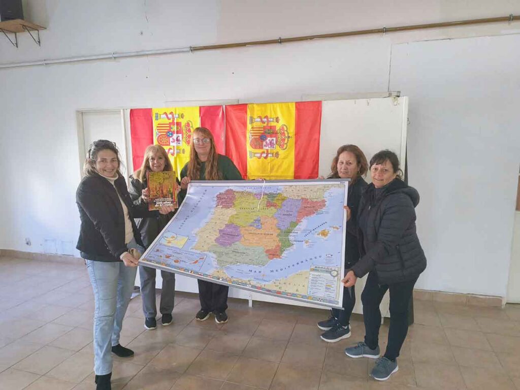 Directivos de la Sociedad Española de Pirovano con el mapa y las banderas de ceremonia.