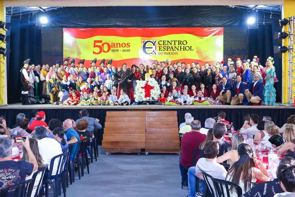 Grupos folclóricos junto a la imagen de la Virgen del Pilar en el escenario.